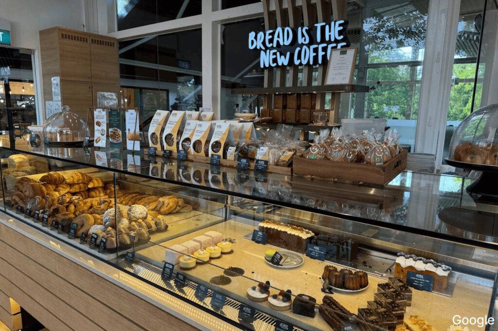 A selection of different breads in a bakery display case, highlighting the inviting atmosphere of local cafes and brunch spots.