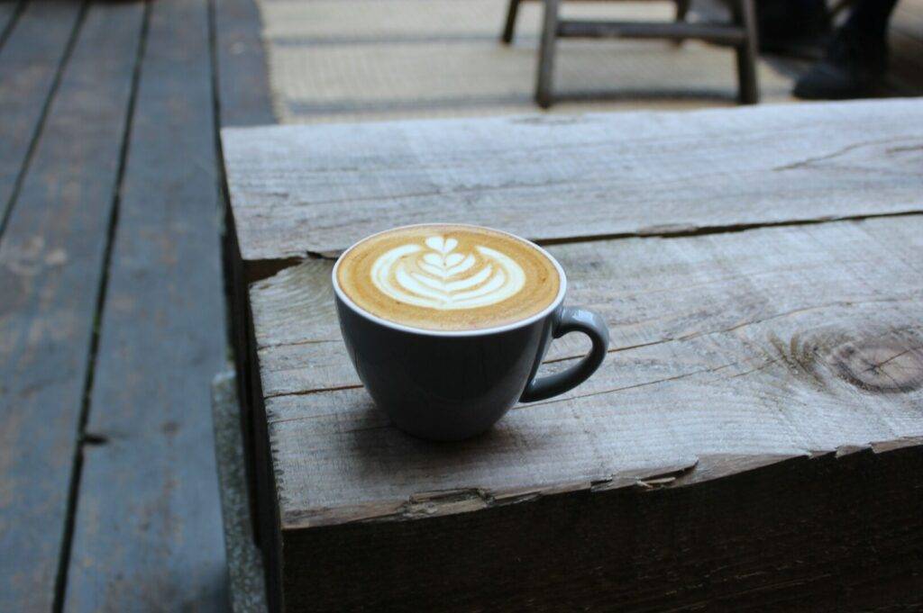 A coffee cup placed on a wooden table, highlighting Singapore's rich cafe culture.
