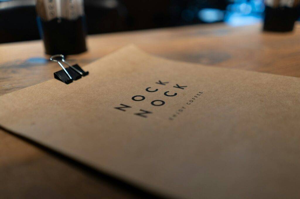 A menu of the Nock Nock Coffee, printed on a brown paper and clipped to match the shops atmosphere and character.