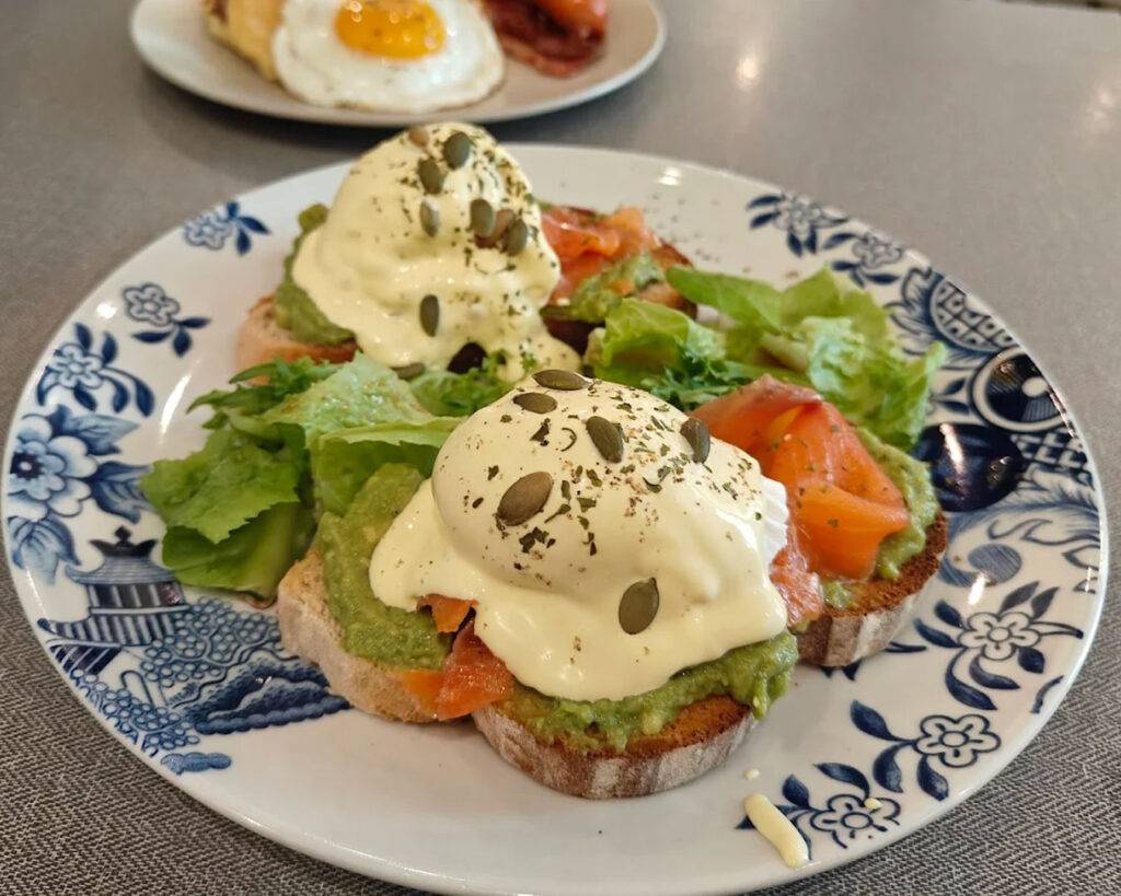 A wholesome breakfast featuring crusty bread and creamy eggs, presented on rustic tableware that reflects the café’s cosy, minimalist vibe.