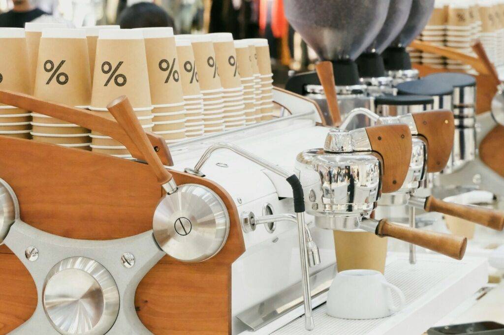 A row of coffee machines in a bustling Singapore coffee shop, showcasing various brewing styles and equipment.