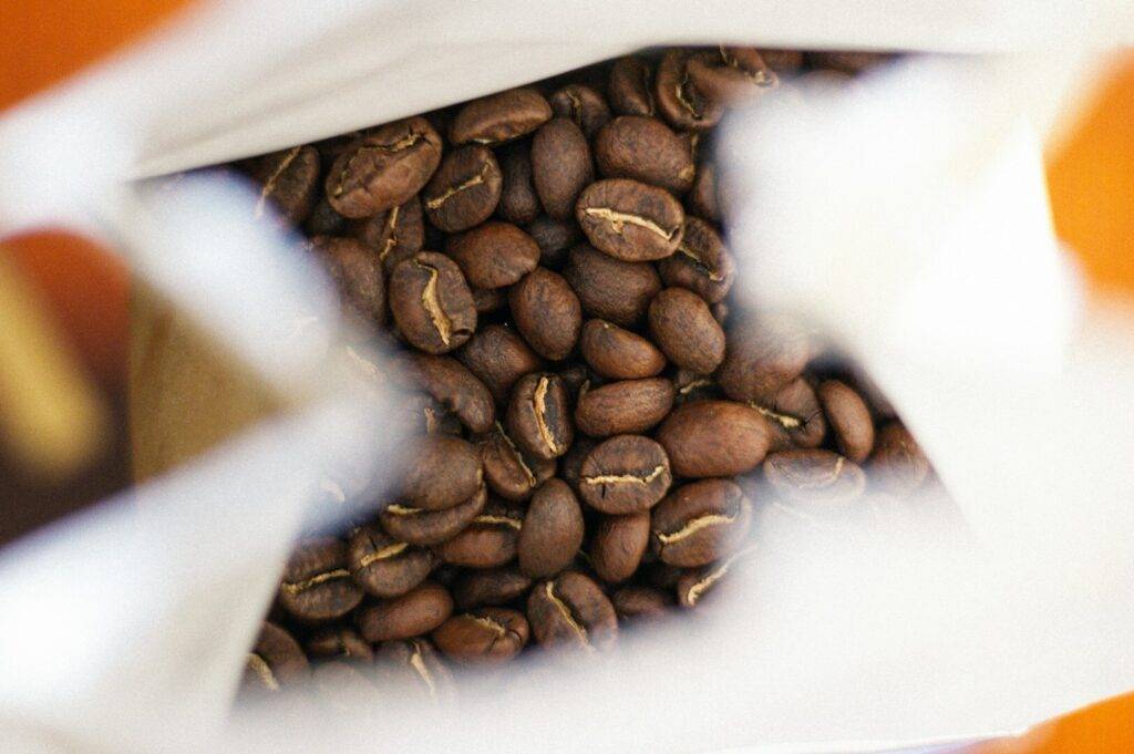 A bag of medium roasted coffee beans, highlighting the earthy tones and aroma of freshly roasted coffee.
