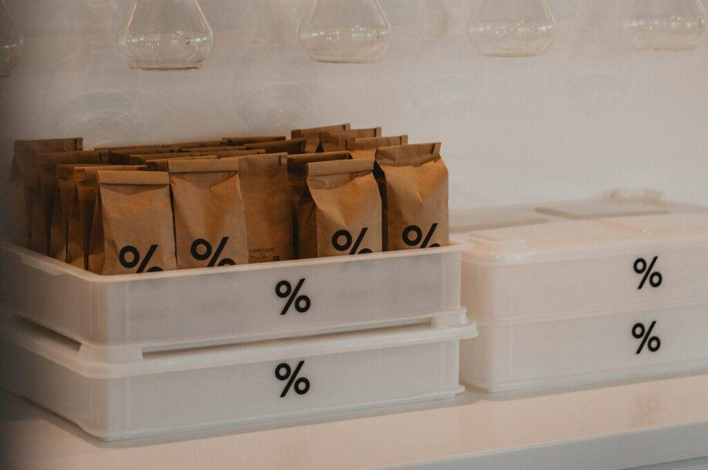 A white shelf on a counter displaying two containers in a coffee shop in Singapore.
