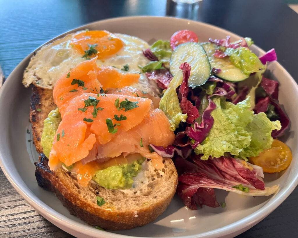 A rustic slice of sourdough served with a fresh garden salad, balancing crisp greens with the warm, lightly toasted bread for a wholesome café-style meal.