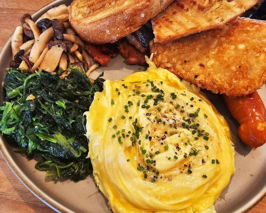 A comforting brunch plate featuring crispy hash browns and sautéed mushrooms, served warm and satisfying for a leisurely morning meal.