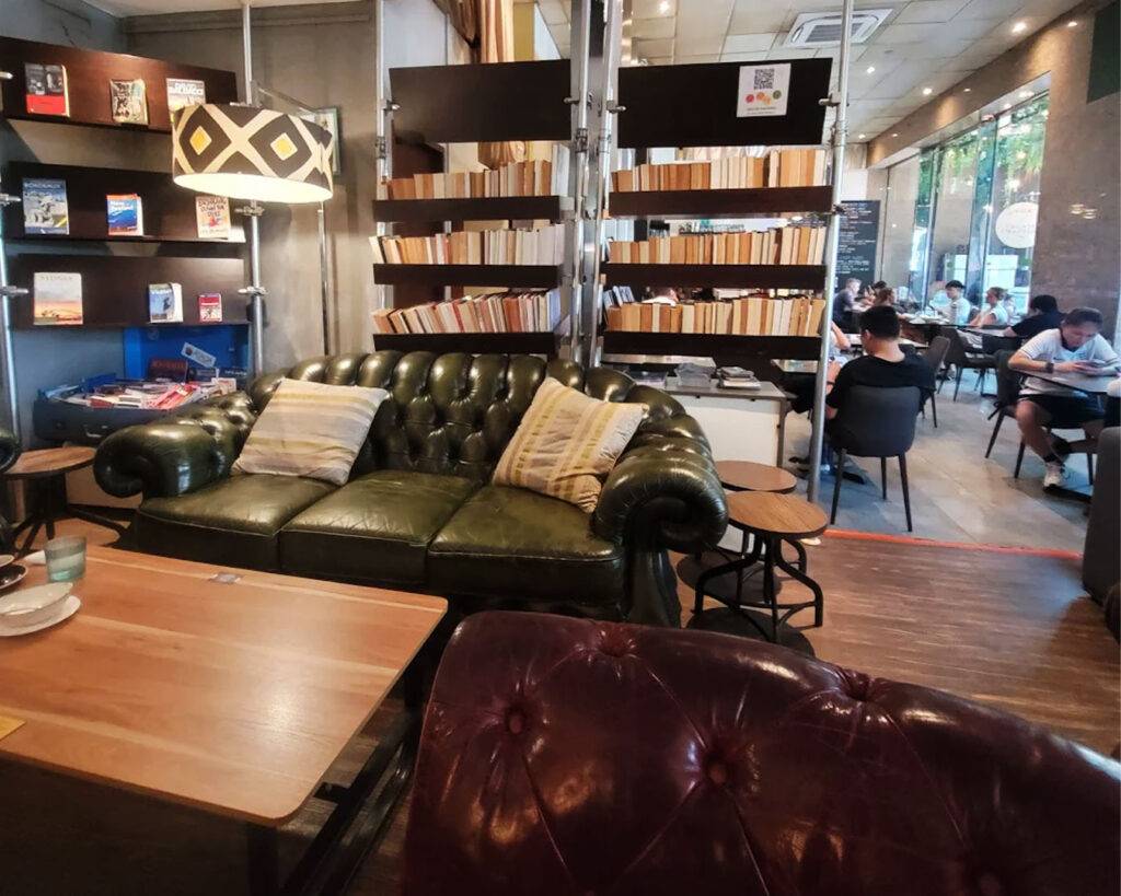 A cosy seating area with soft sofas and wooden tables, designed for comfort and relaxation, offering a quiet corner for reading, working, or casual conversations.