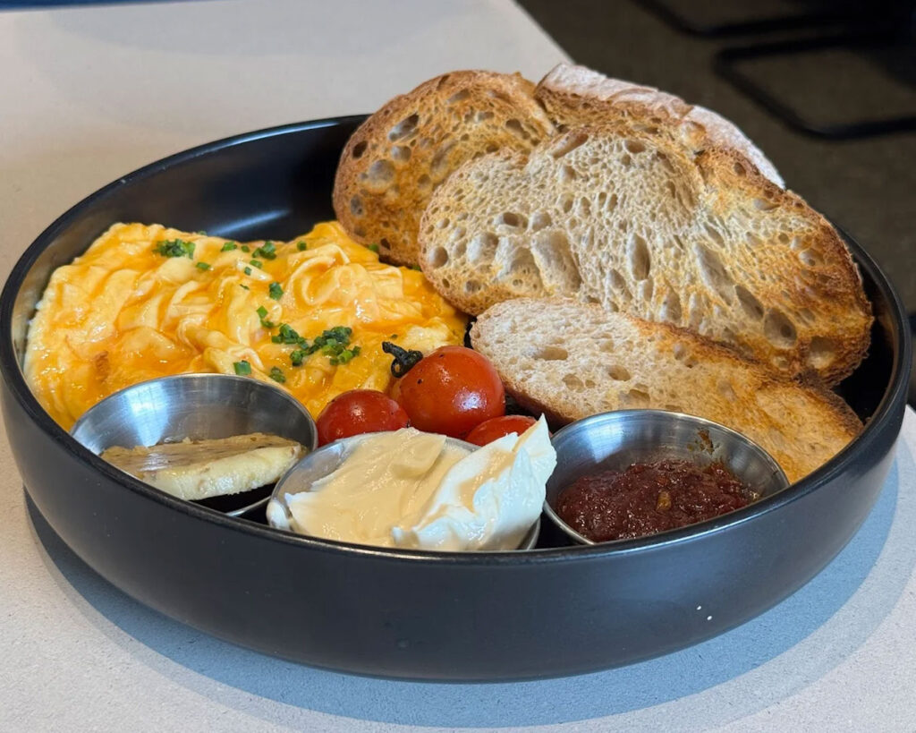 A freshly brewed cup of coffee placed on a wooden table at Atlas Coffeehouse, with soft natural light and a relaxed café atmosphere in the background.