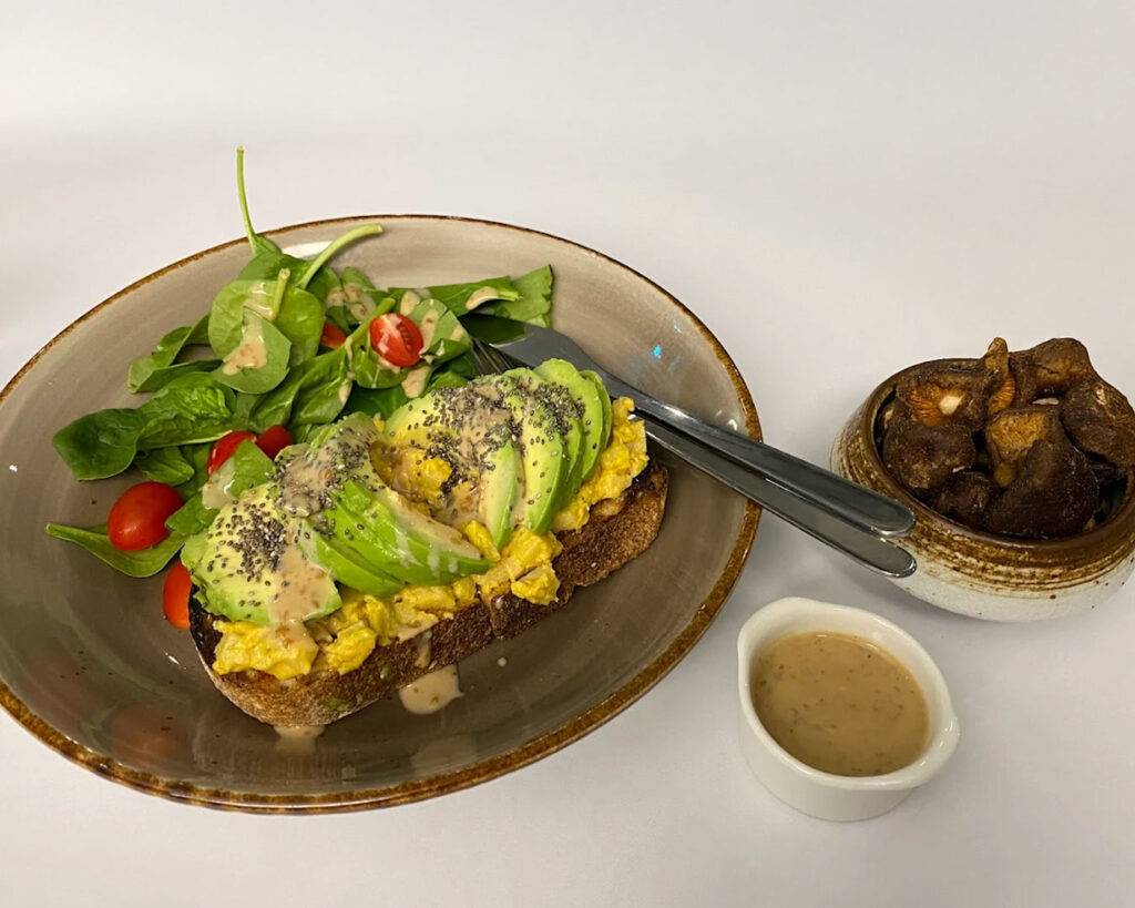 : A close-up of a human meal at The Barking Bean Singapore, showing a well-presented dish with fresh ingredients on a wooden table.