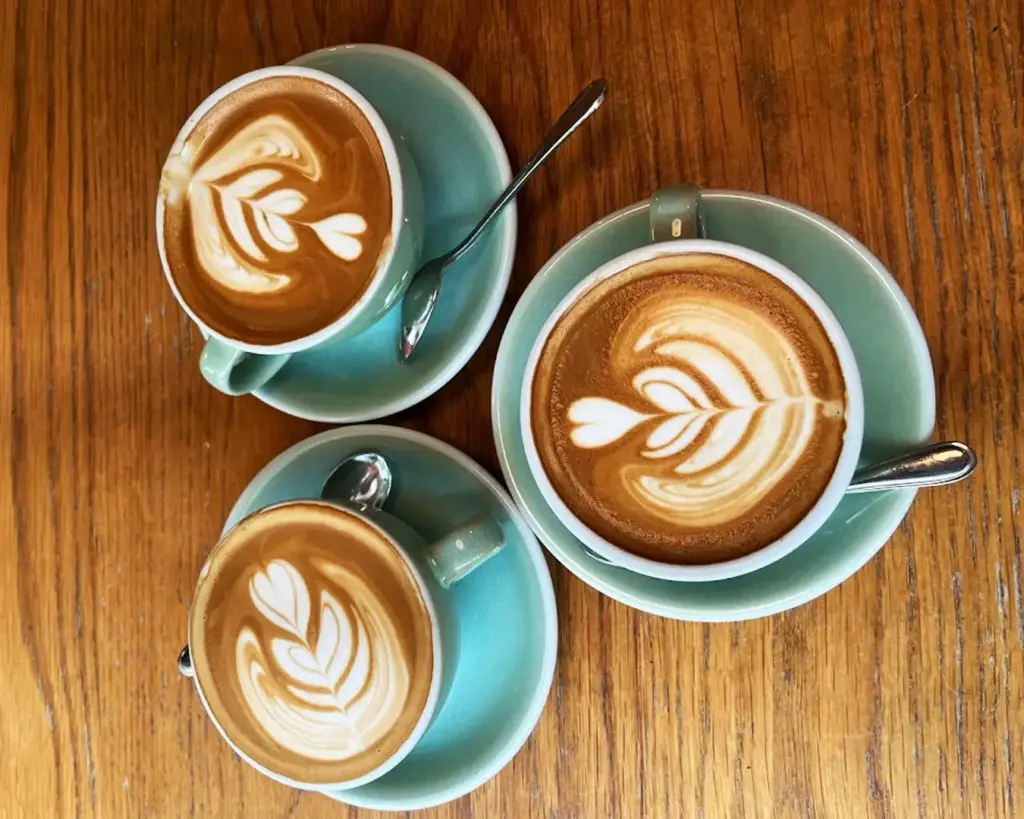 Three cups of freshly brewed coffee arranged together, highlighting different textures and tones, perfect for a shared coffee moment.