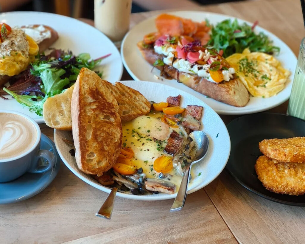 A variety of dishes displayed on a dining table at The Brewing Ground, featuring different plates and textures that highlight the café’s diverse menu and generous portions.