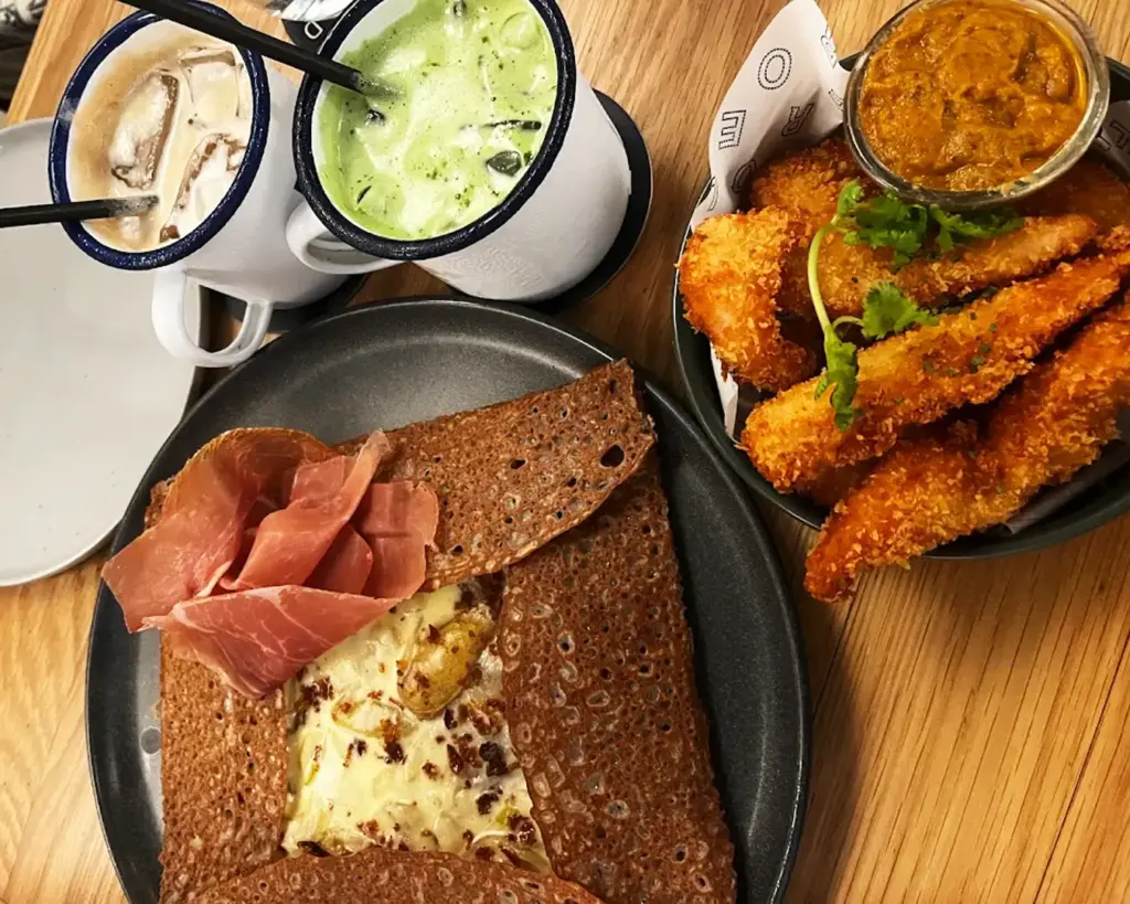 A classic crepe served with rich French butter and a hint of lemon zest, accompanied by slices of savoury meats for a refined and balanced dish.