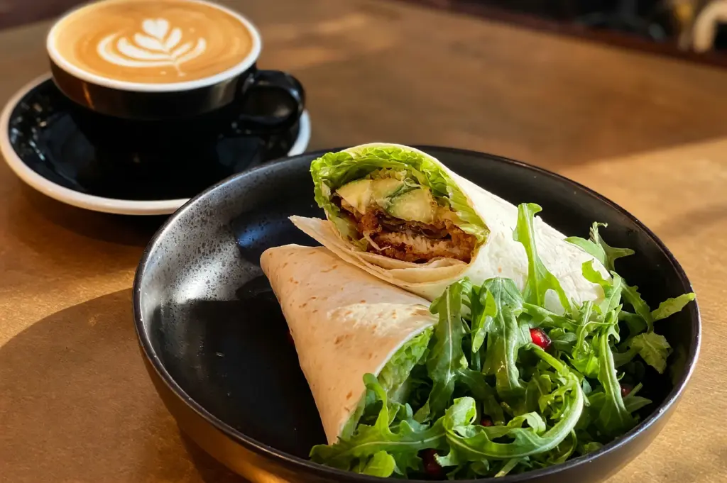 A delicious tempura unagi wrap served with a side of fresh greens, paired with a cup of specialty coffee from Chye Seng Huat Hardware at Jalan Besar.