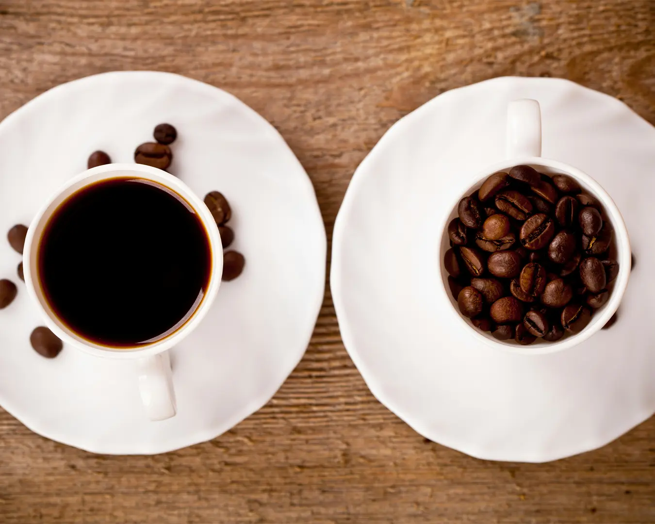 A freshly brewed cup of coffee placed beside a small pile of roasted coffee beans, highlighting the rich ingredients used to create a flavourful and aromatic coffee.