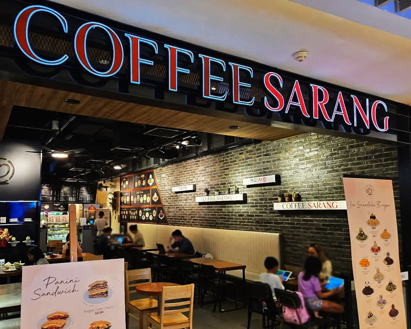 The front exterior of Coffeesarang café, featuring a welcoming storefront with modern Korean café aesthetics and a cosy atmosphere that invites customers inside.