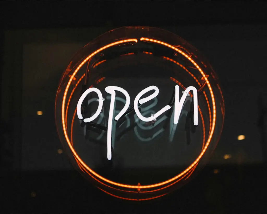 A welcoming “Open” sign displayed at the café entrance, signalling that the space is ready to receive guests, adding a friendly and inviting touch to the storefront.