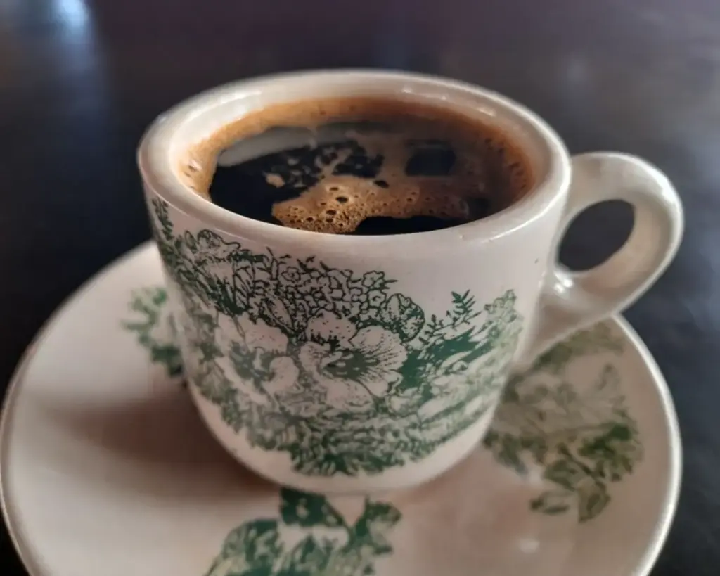 A cup of traditional Kopi O, a strong black coffee commonly served in Southeast Asia, presented in a classic cup with its deep, dark colour.