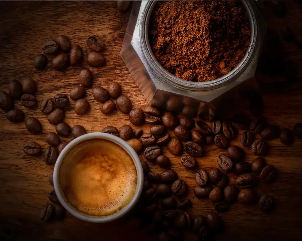 A cup of freshly brewed coffee surrounded by Arabica coffee beans, showcasing the premium beans known for their smooth flavour and aromatic profile.