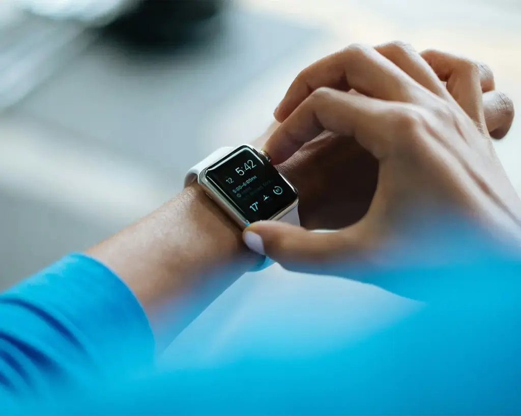 A person touching and looking at a wristwatch on their other hand, symbolising checking the time during a busy or scheduled moment.