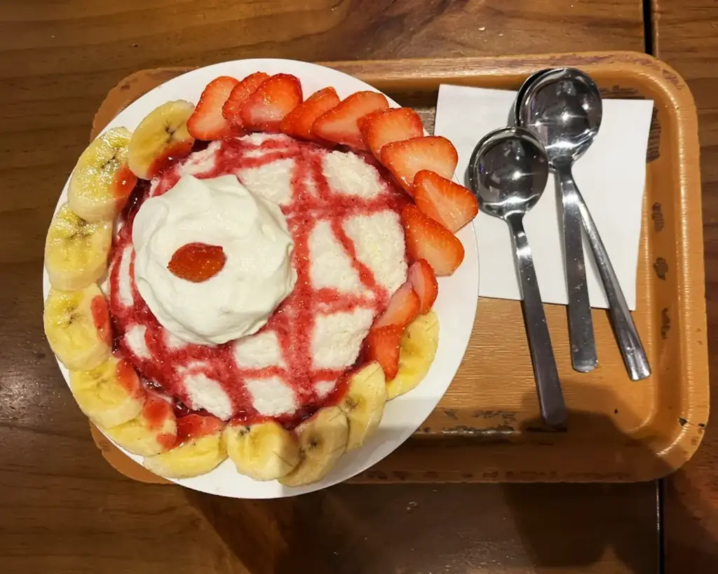 An authentic Korean-style dessert featuring fresh banana and strawberry, presented with a soft, sweet base that highlights the light and fruity flavours popular in Korean cafés.