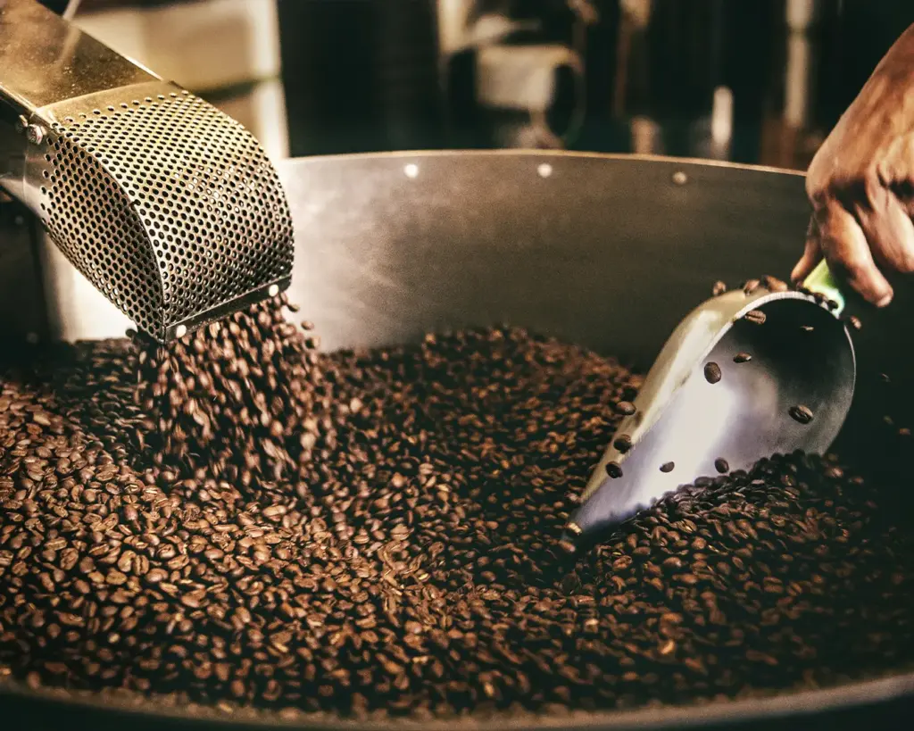 A coffee roaster machine roasting coffee beans, showing the process that develops the beans’ rich aroma and flavour.