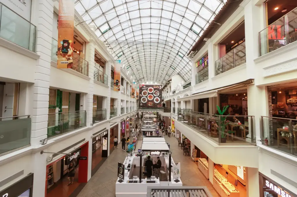 An eye-level view of a shopping mall atrium in Singapore, showcasing the Bugis and Bras Basah area, which is a popular home for book cafes and other work-friendly coffee spots that offer free wifi for remote workers.