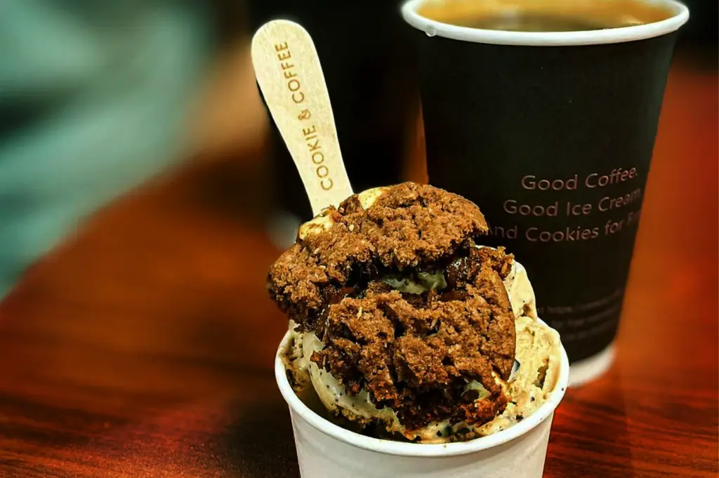 A close-up shot showcasing a cup of artisanal ice cream topped with a cookie and a takeaway coffee cup, highlighting why cafes in Fortune Centre are perfect for light visits and a flexible stop for patrons.