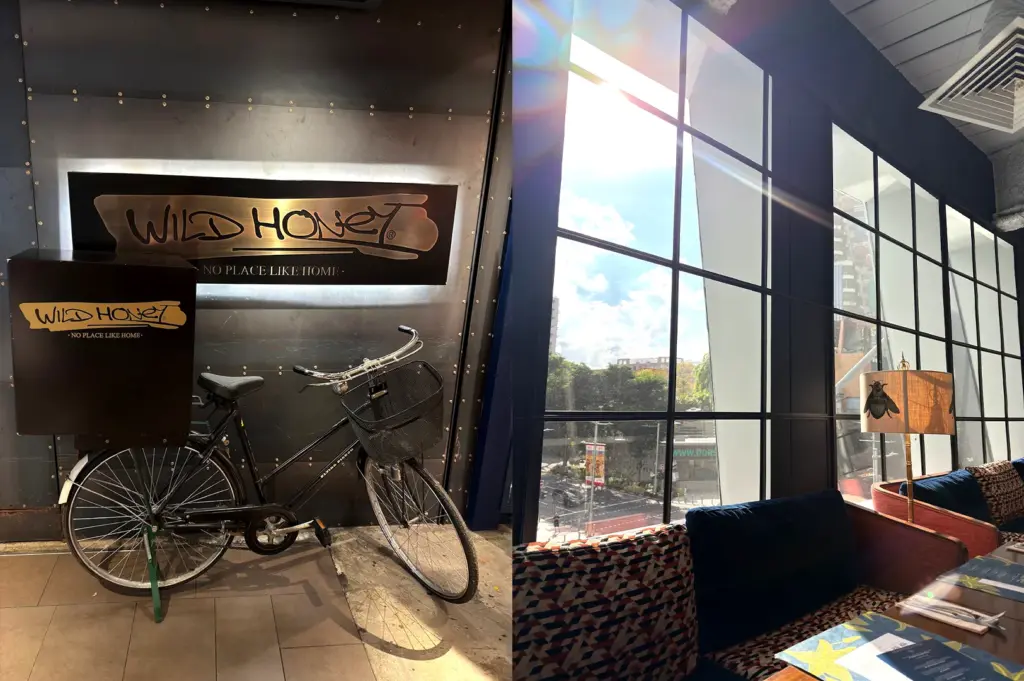The iconic Wild Honey bicycle signage at the entrance and a view of the bright, sunlit seating area by the windows at Mandarin Gallery, showcasing the cafe's inviting atmosphere.