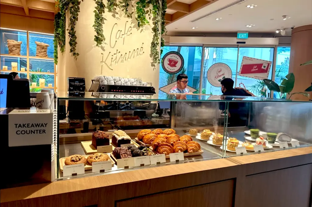 Detailed display case at the service counter of Café Kitsuné Capitol Singapore, filled with freshly baked croissants, artisan pastries, and colorful gourmet desserts for takeaway or dine-in.