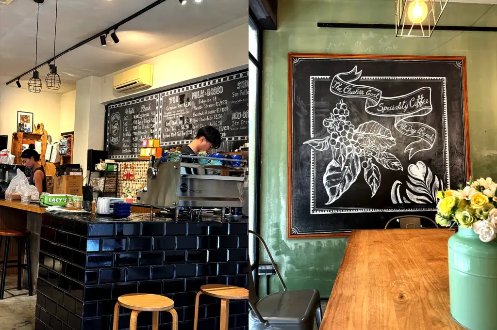 The interior counter area of The Clueless Goat, featuring a large chalkboard menu and artistic coffee bean illustration on the wall.