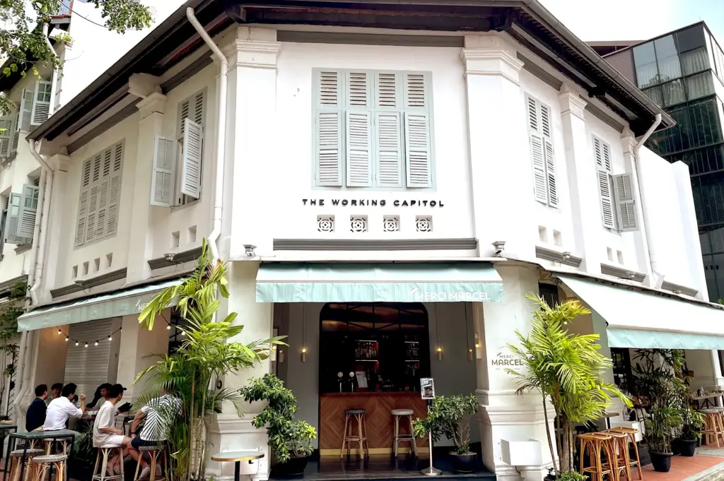 The charming facade of Merci Marcel at Club Street, capturing the vibrant atmosphere of its outdoor seating area and heritage shophouse aesthetic.