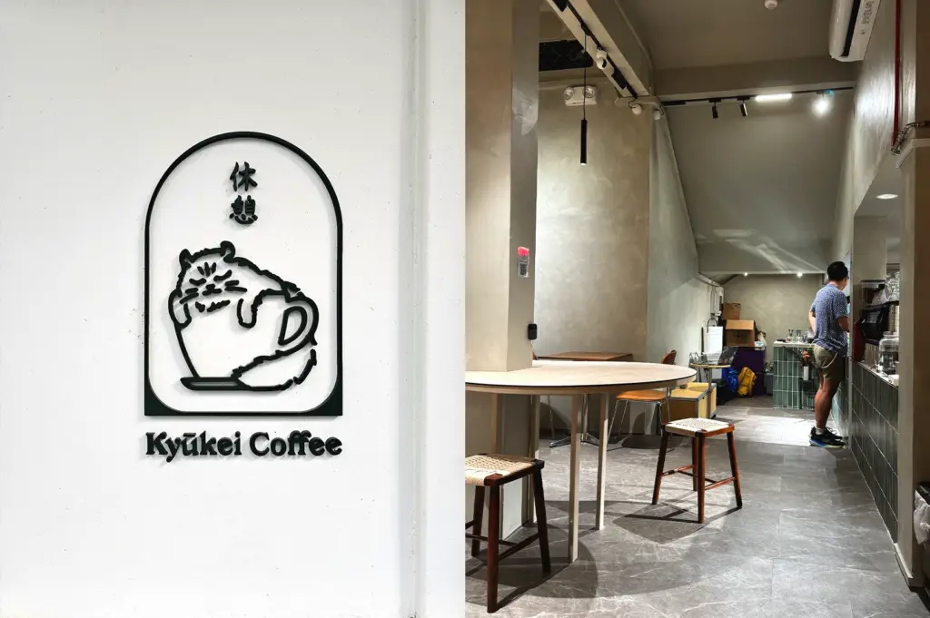 A minimalist wall featuring the cute signature cat logo of Kyuukei Coffee, creating a recognisable and aesthetic photo spot inside this cosy Singaporean café.