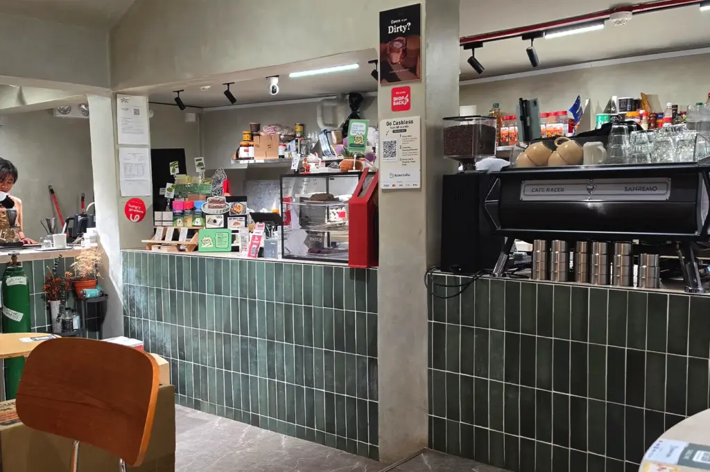A view of the main service counter at Kyuukei Coffee, featuring green tiles and professional coffee equipment, reflecting the clean, modern, and welcoming design of the shop.