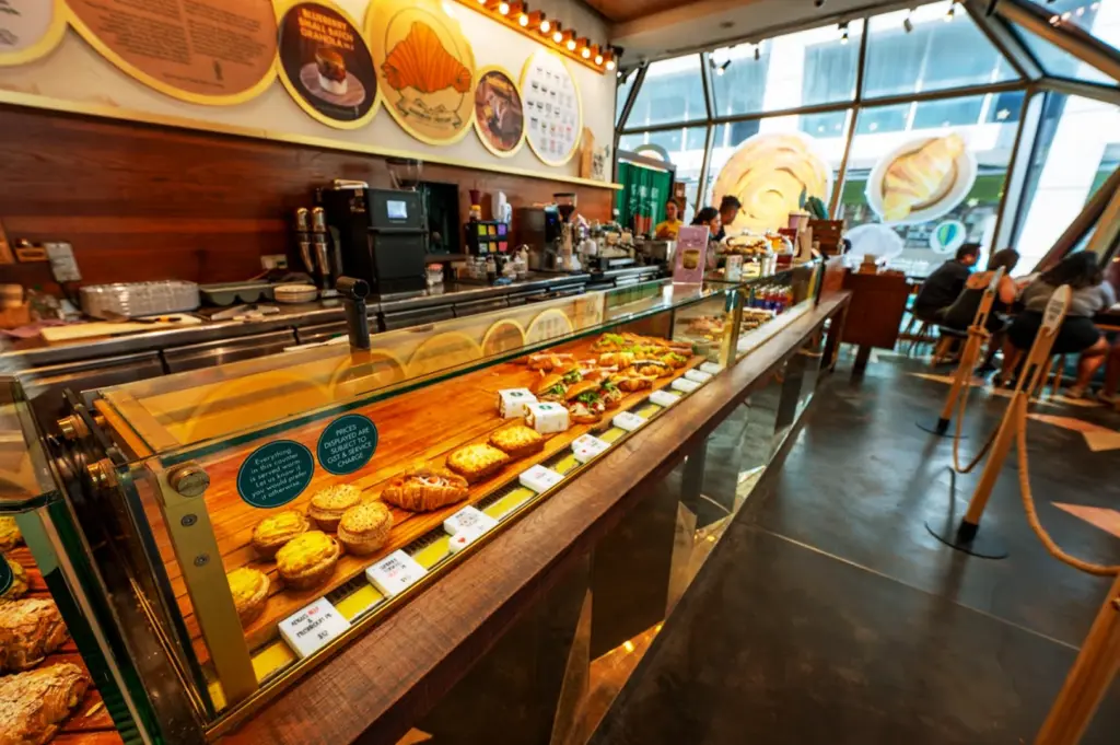 A mouth-watering display of pastries and pies behind the glass counter at Tiong Bahru Bakery in Singapore, showcasing their signature artisanal bakes.