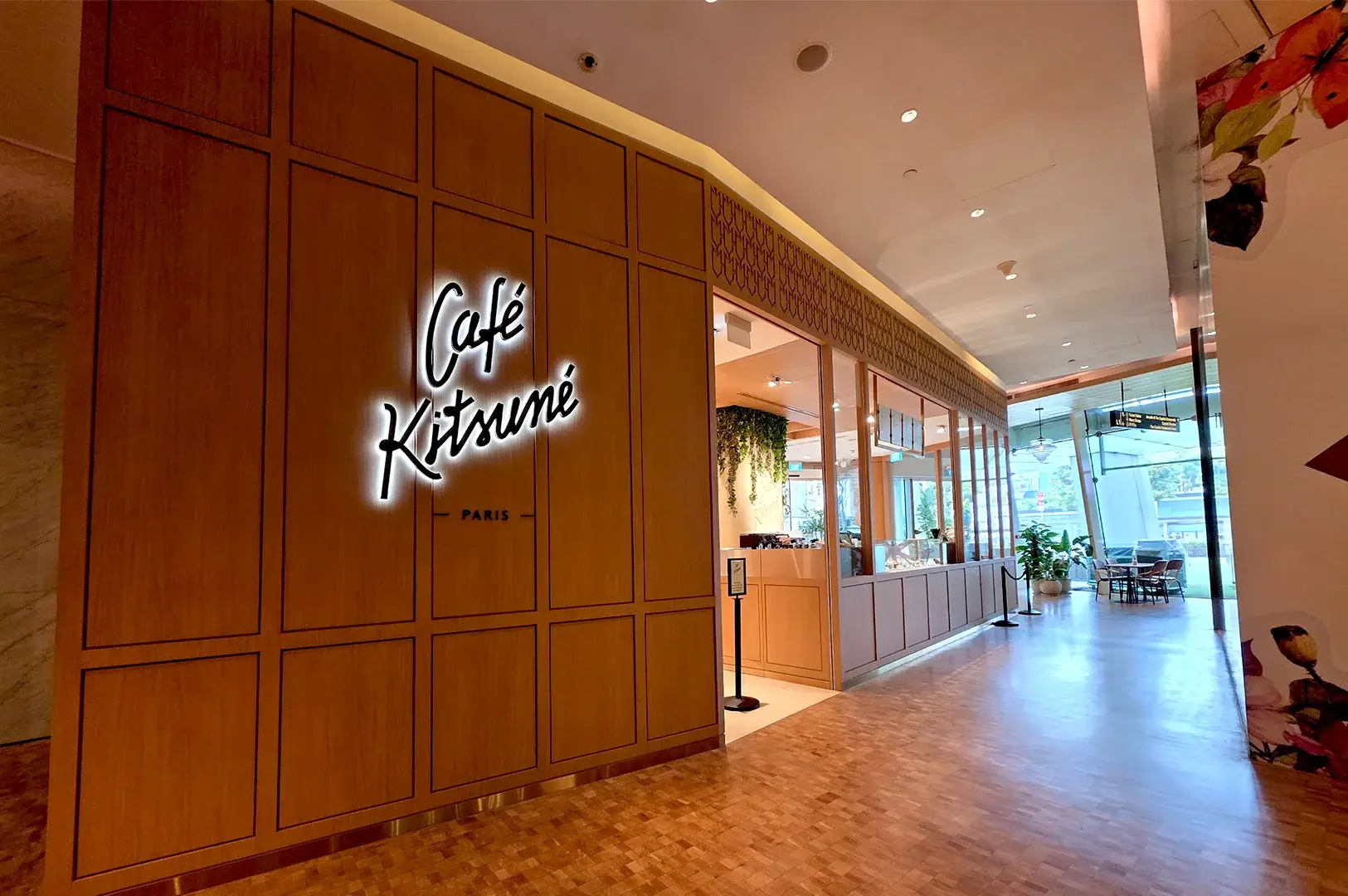 Elegant wooden storefront of Café Kitsuné at Capitol Singapore, featuring its iconic minimalist branding and inviting entrance for coffee lovers in the city center.