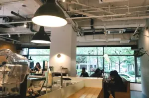 Interior of a Singapore coffee shop, with customers seated at tables, immersed in conversation and coffee culture.