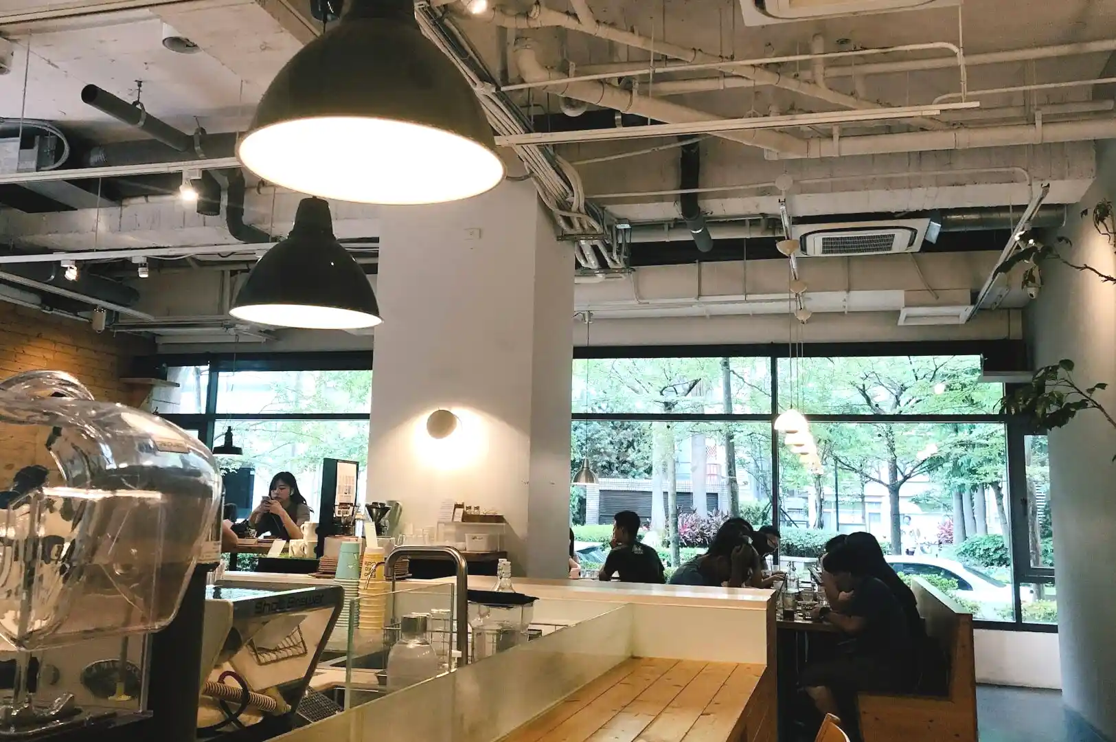 Interior of a Singapore coffee shop, with customers seated at tables, immersed in conversation and coffee culture.