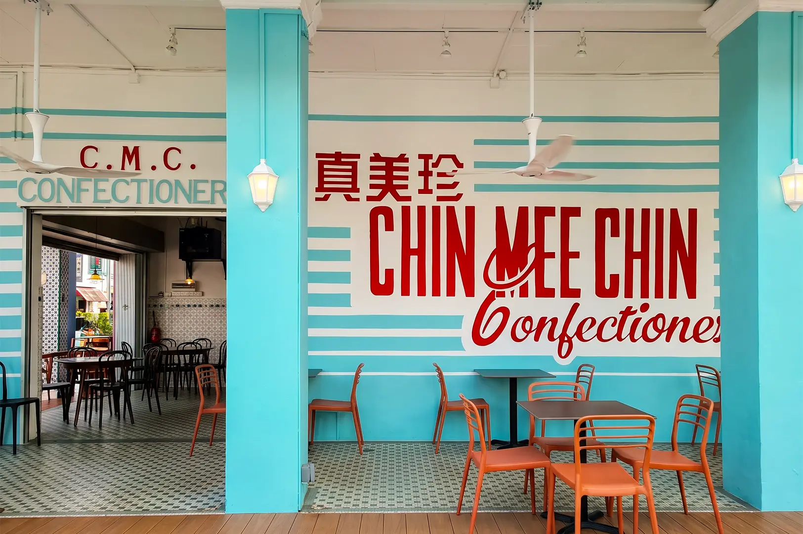 Chin Mee Chin exterior with chairs and tables placed below the logo text on the wall.