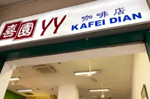 YY Kaferi Dian store exterior focus shot on their logo signage above the entrance with its red, white, and blue color scheme.