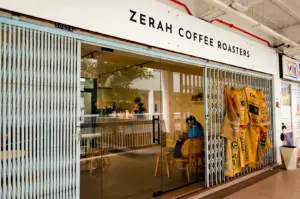 Zerah Coffee Roasters exterior with its minimalist logo signage on top and a glass entrance revealing its cozy interior.