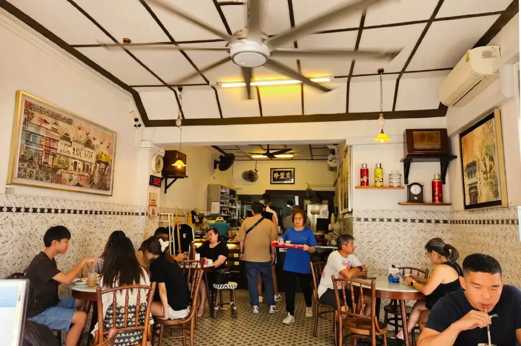 Chin Mee Chin interior with customers dining and ordering in a white and brown marble walls and tables.