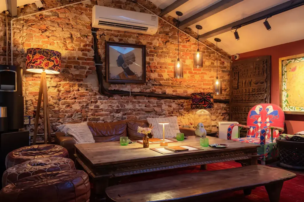Kafe Utu coffee table with African inspired furniture surrounding the wooden table and cushioned chairs.