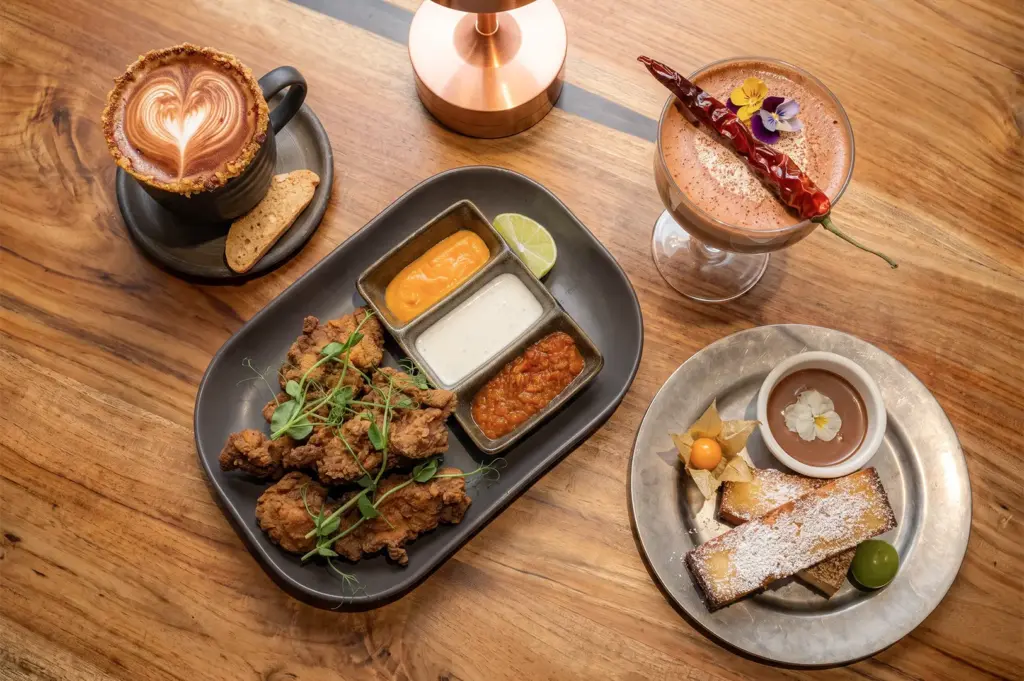 Flat lay high angle shot of menu items served at Kafe Utu featuring African cuisine with chicken and coffee.
