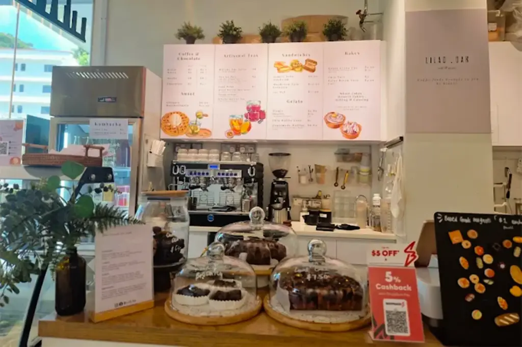 Lilac Oak counter and menu items on display with white minimalist style, available pastry menus and potted plants on display in front.