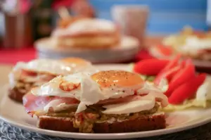 Eggs on a bread plated with other breakfast dishes.