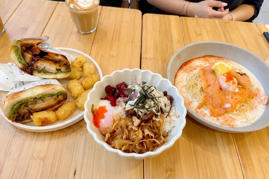 menu items served at For You People Cafe in white bowls and plates on a wooden table.