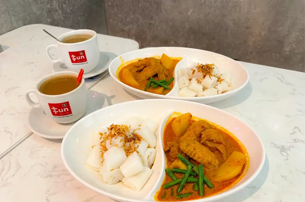 Fun Toast Orchard Curry Chicken with Chee Cheong Fun served in white oval plates together with cups of coffee.