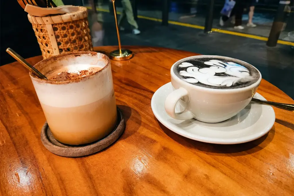 A closer view of Rise Bakehouse coffee cups side by side each other on a round wooden table.