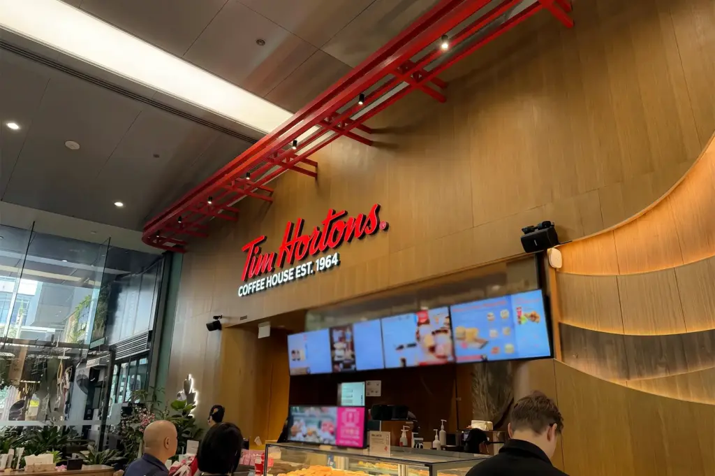 Tim Hortons logo signage above their digital menu and counter.