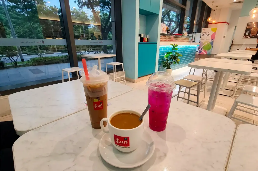 Curry Chicken with Chee Cheong Fun drink items including kopi and coffee milk teas neatly arranged on their table.